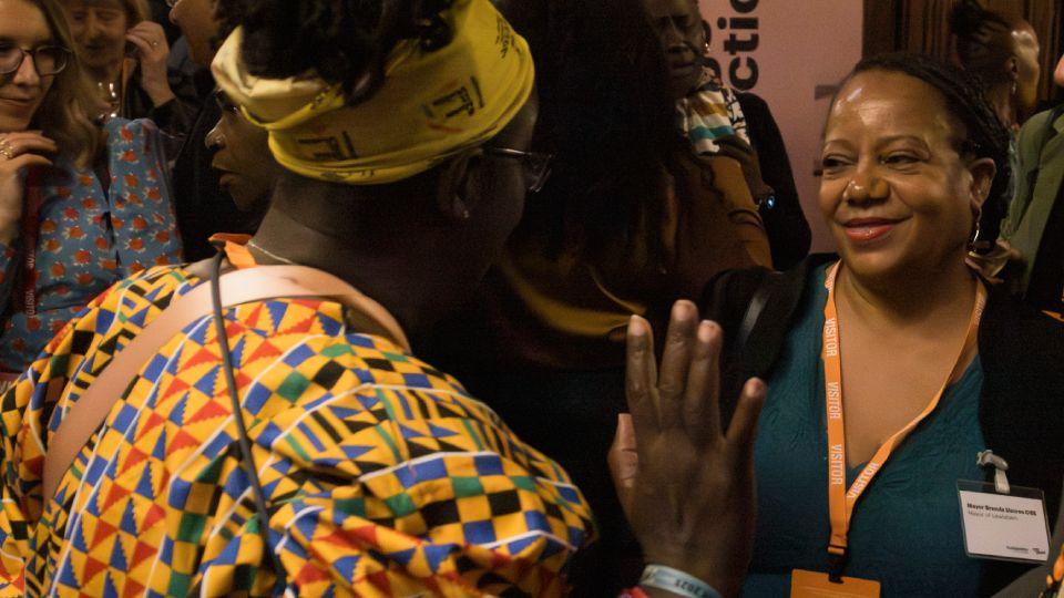 Two females in conversation. Brenda Dacres on right, Rosamund Kissi-Debrah on left