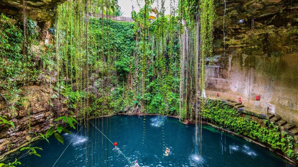 Mexican Cenote - blue water pool, surrounded by rock and vegetation