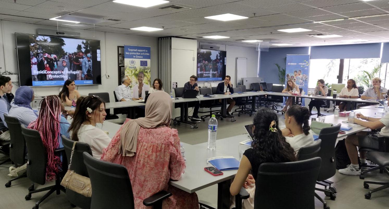Students sitting around desks arranged in a big square shape	