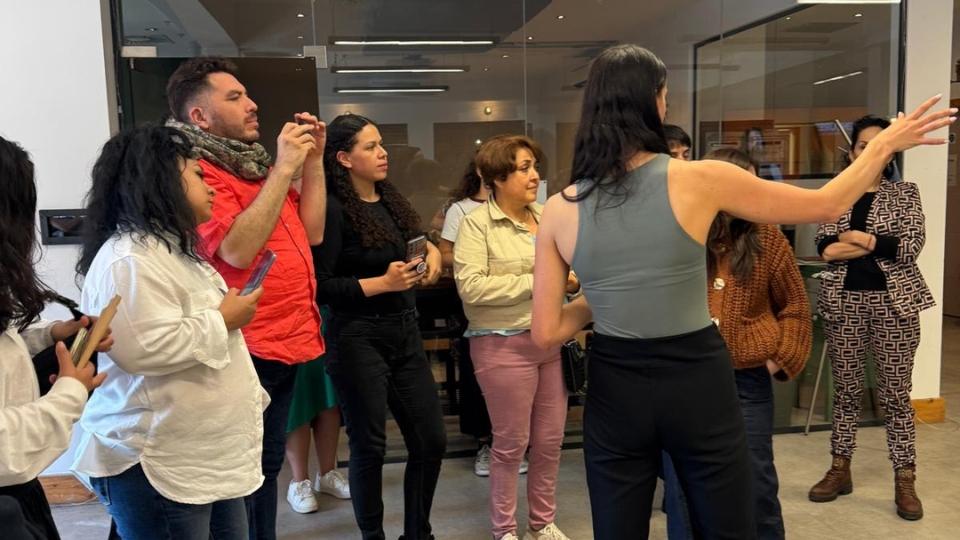 Group of people being directed by a woman standing