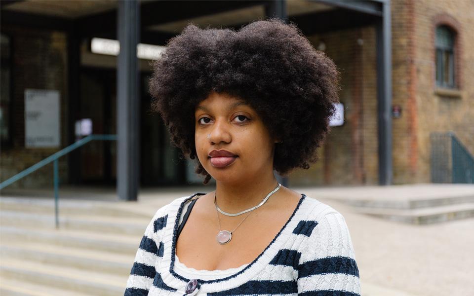 Chantel, a black woman, stands in front of Goldsmiths CCA.