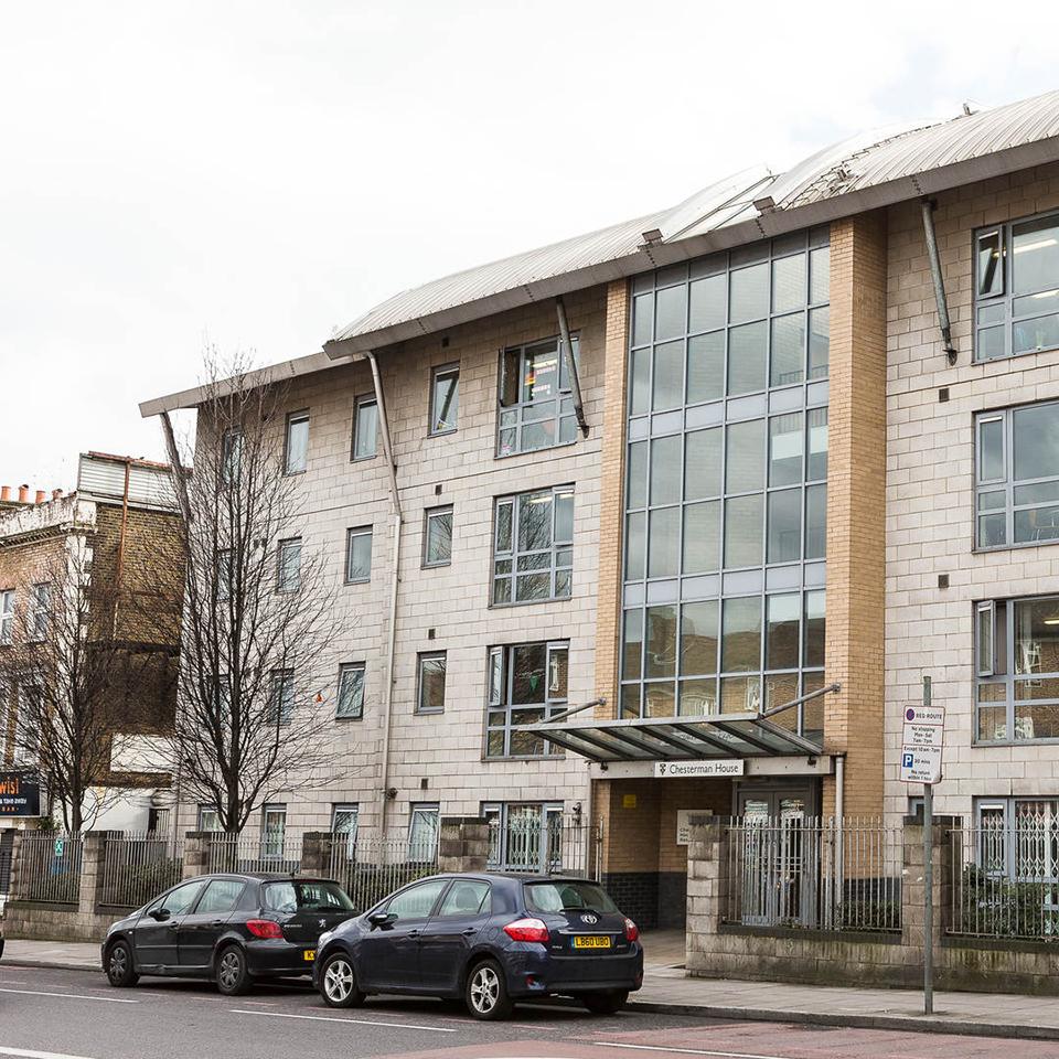 Inside a tidy student room with pictures on the wall and a wooden desk unit.