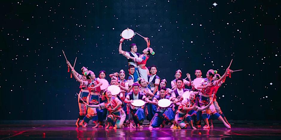 Chinese spirit dance on stage showing one central person being lifted by the others.