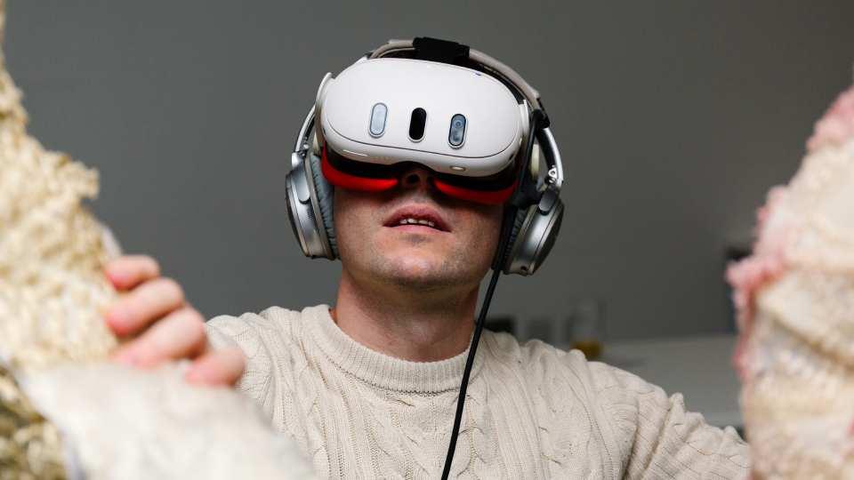 Male wearing Virtual Reality headset between two branches of a tree