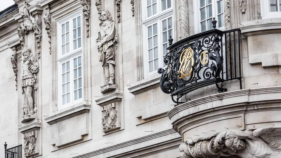 Stoned carved statues of historic figures adorn building facade