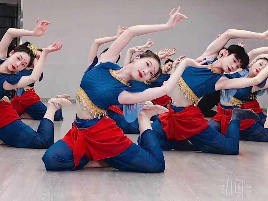 A group of dancers doing a Dunhuang dance pose on the ground