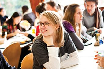 A girl sitting at a desk leaning forward