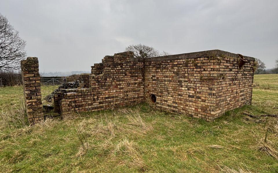 A brick bunker in a field 