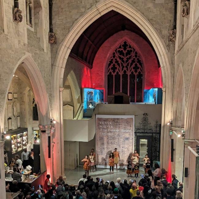 Dancers perform in an old church in front of a crowd at a museum late event