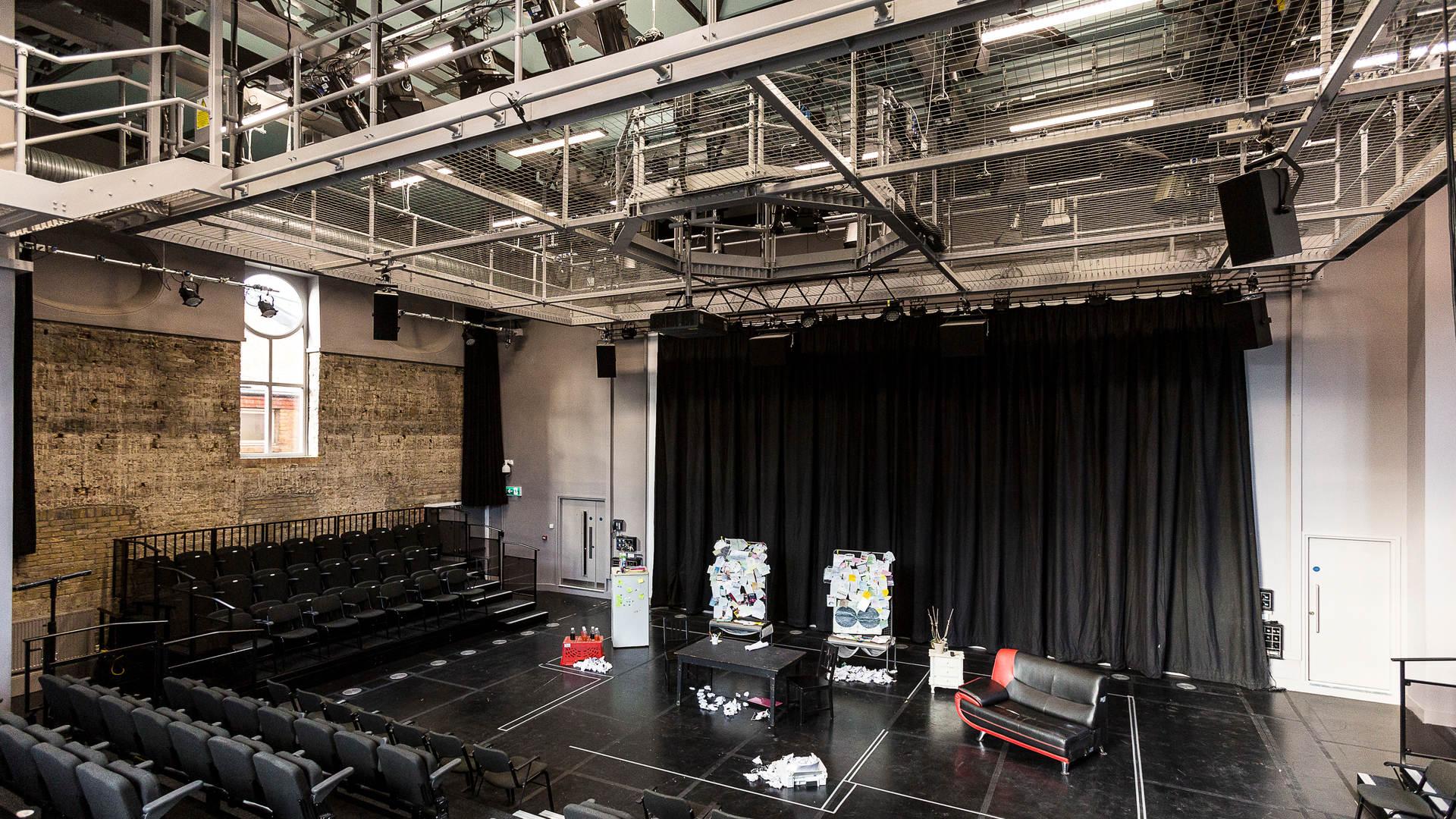 Empty theatre with black chairs and lighting rig