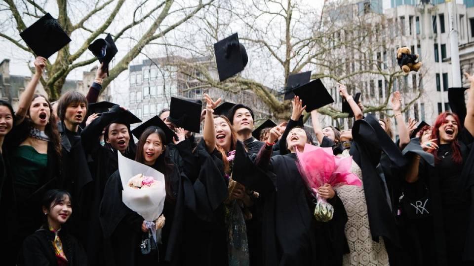 Students throw graduation caps into air