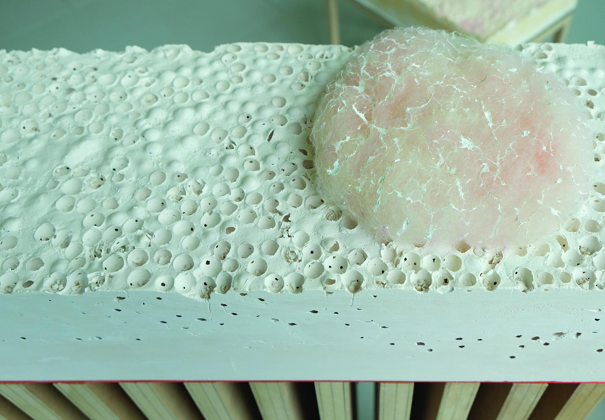 A blue scuptural artwork on a concrete structure