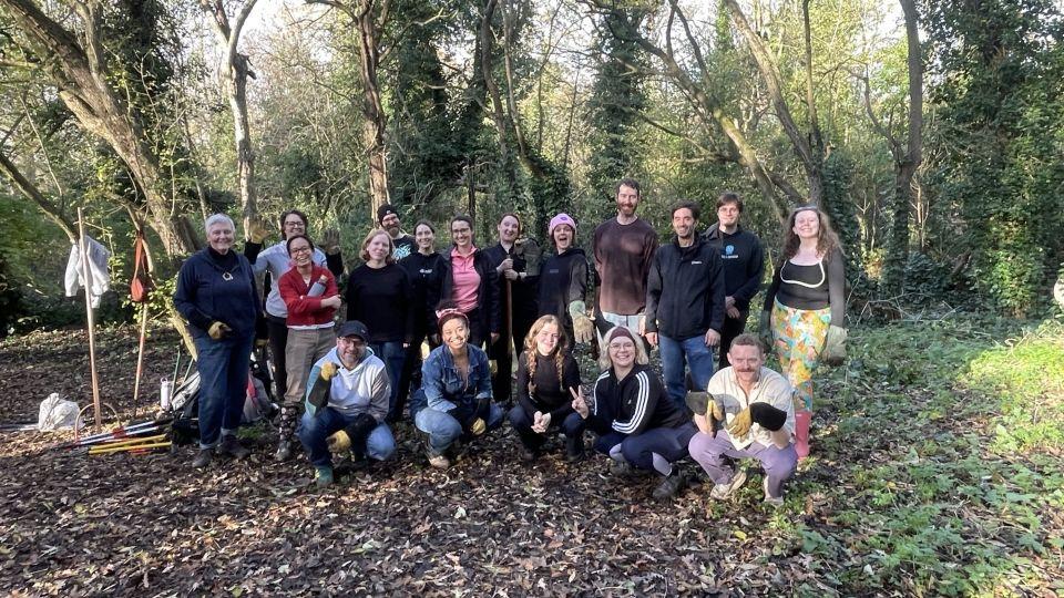 A group photograph of members of staff in a wooded area of Nunhead Cemetery