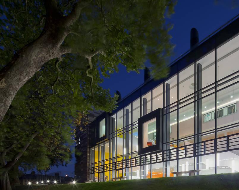 A modern building on the Goldsmiths campus is lit up at night. 