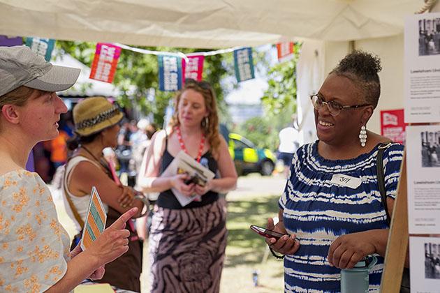 Two women in conversation at a stand of an event