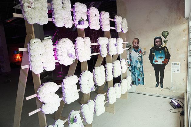 A sign that reads 'Where to now the sequins have gone?' created in purple and white flowers.