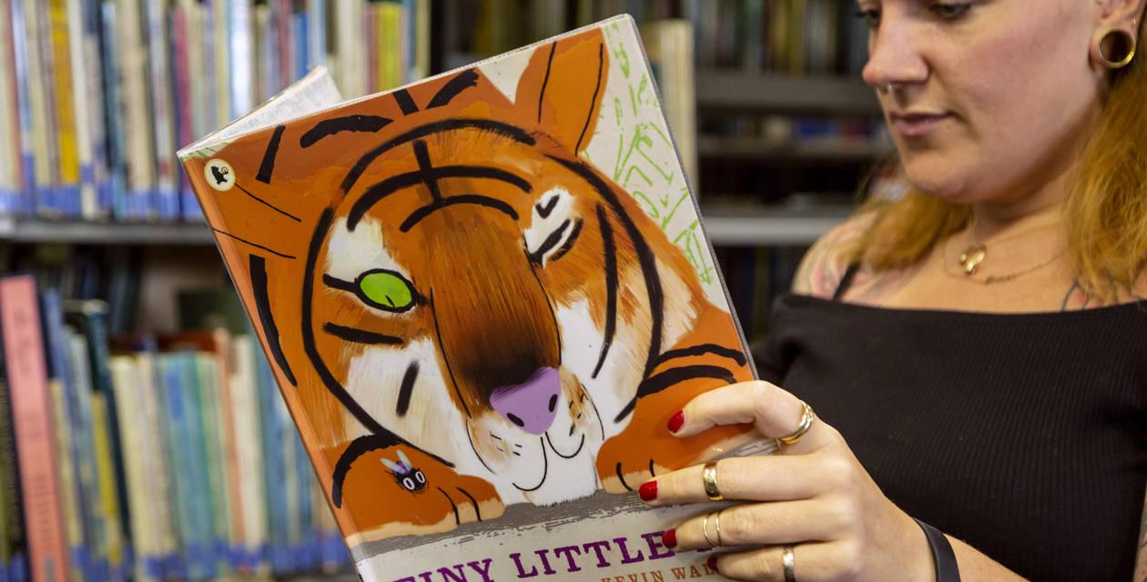 A student reading a children's book.
