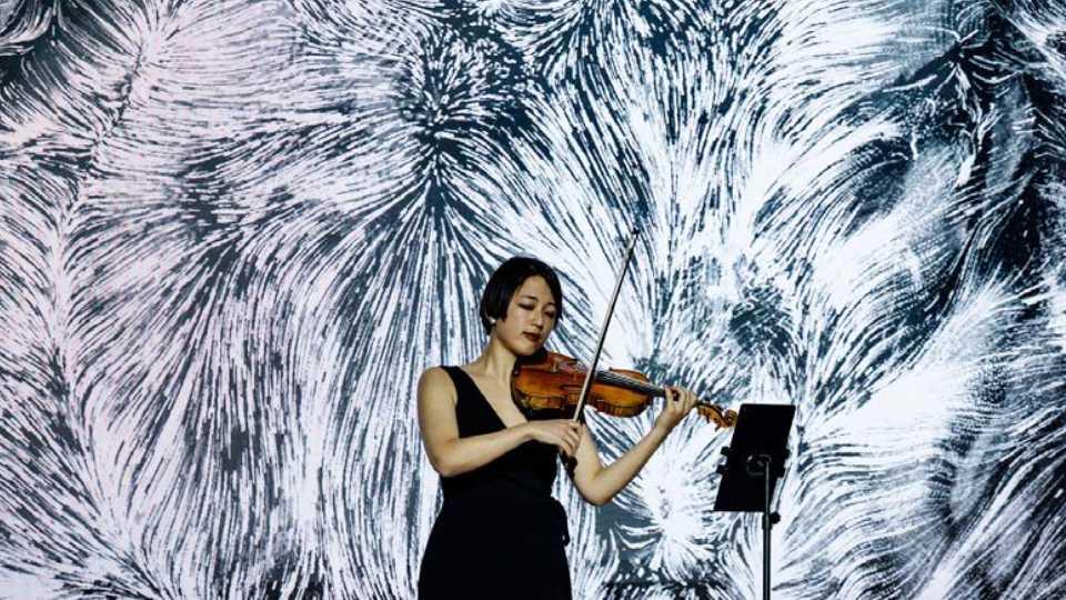 A woman plays a violin with abstract white patterns behind her
