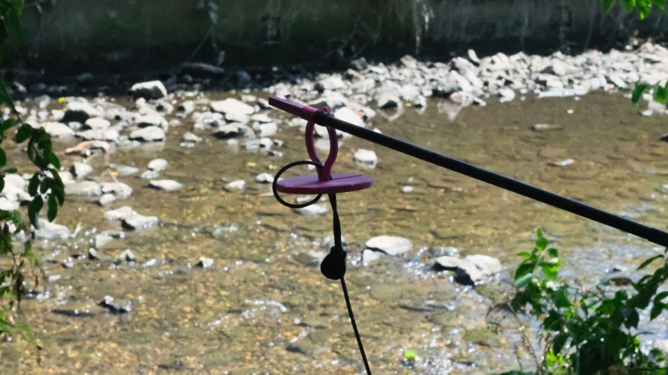 A mic with a pink attachment that lets it float being placed into water with a stick