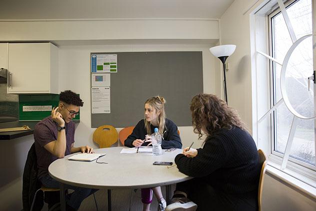 Students sitting around a table in a shared kitchen