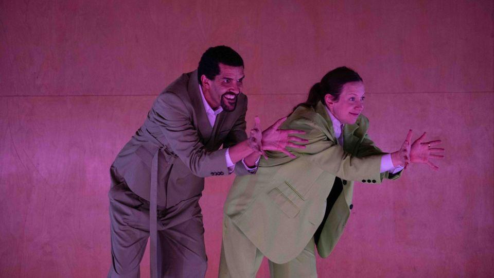Two dancers wearing suits performing