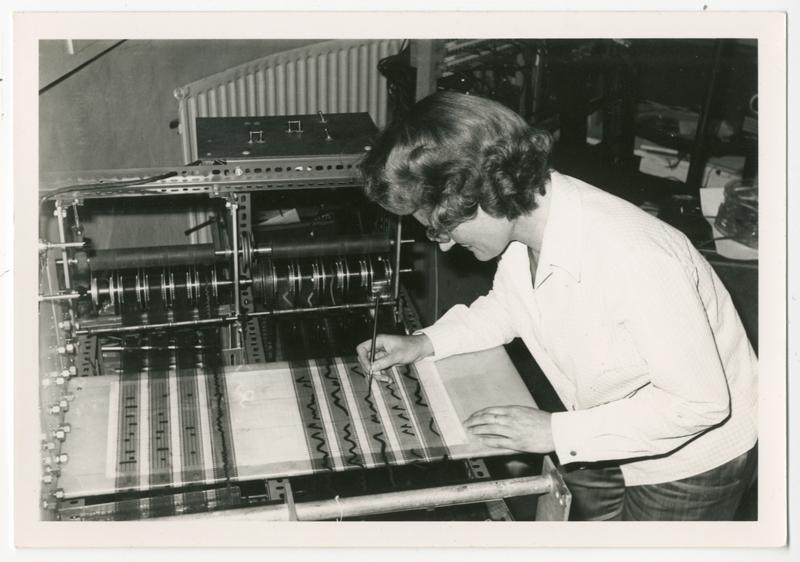 Black and white photo of Daphne Oram drawing on the Oramics Machine she invented 