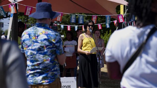 A woman performs spoken word poetry as part of an outdoor festival performance