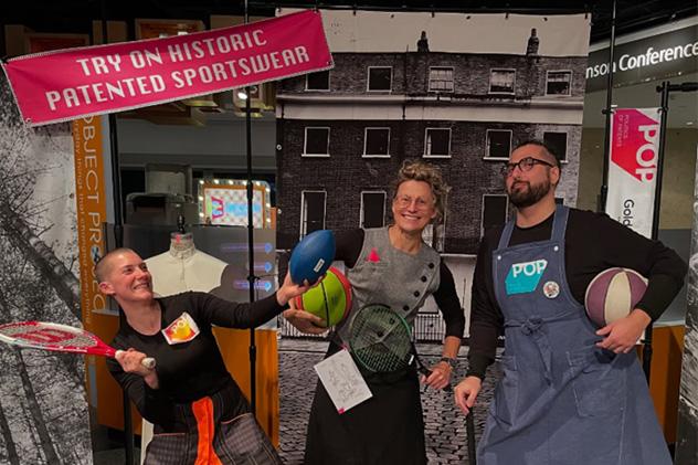 Researchers pose with sporting equipment as part of an interactive museum workshop 