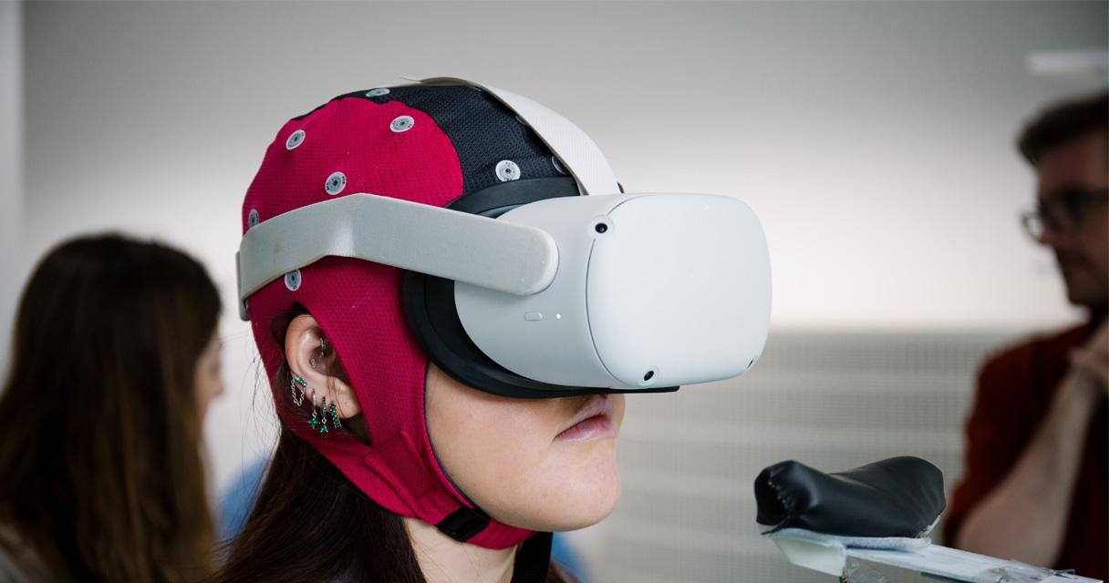 A woman wears a VR headset as part of a psychology experiment