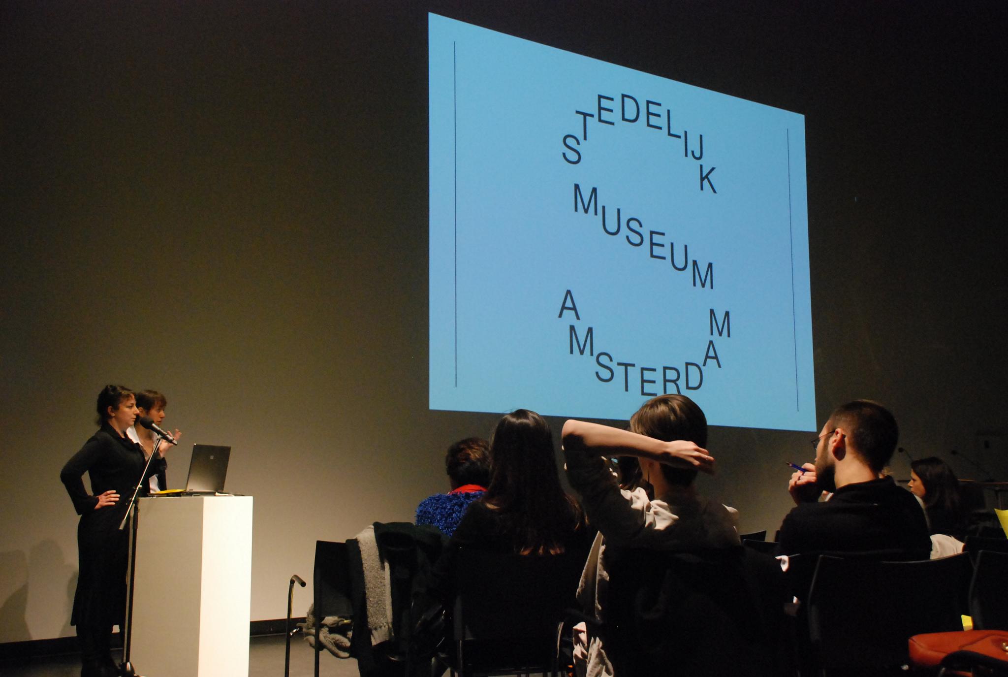 two lecturers show slides to a lecture hall