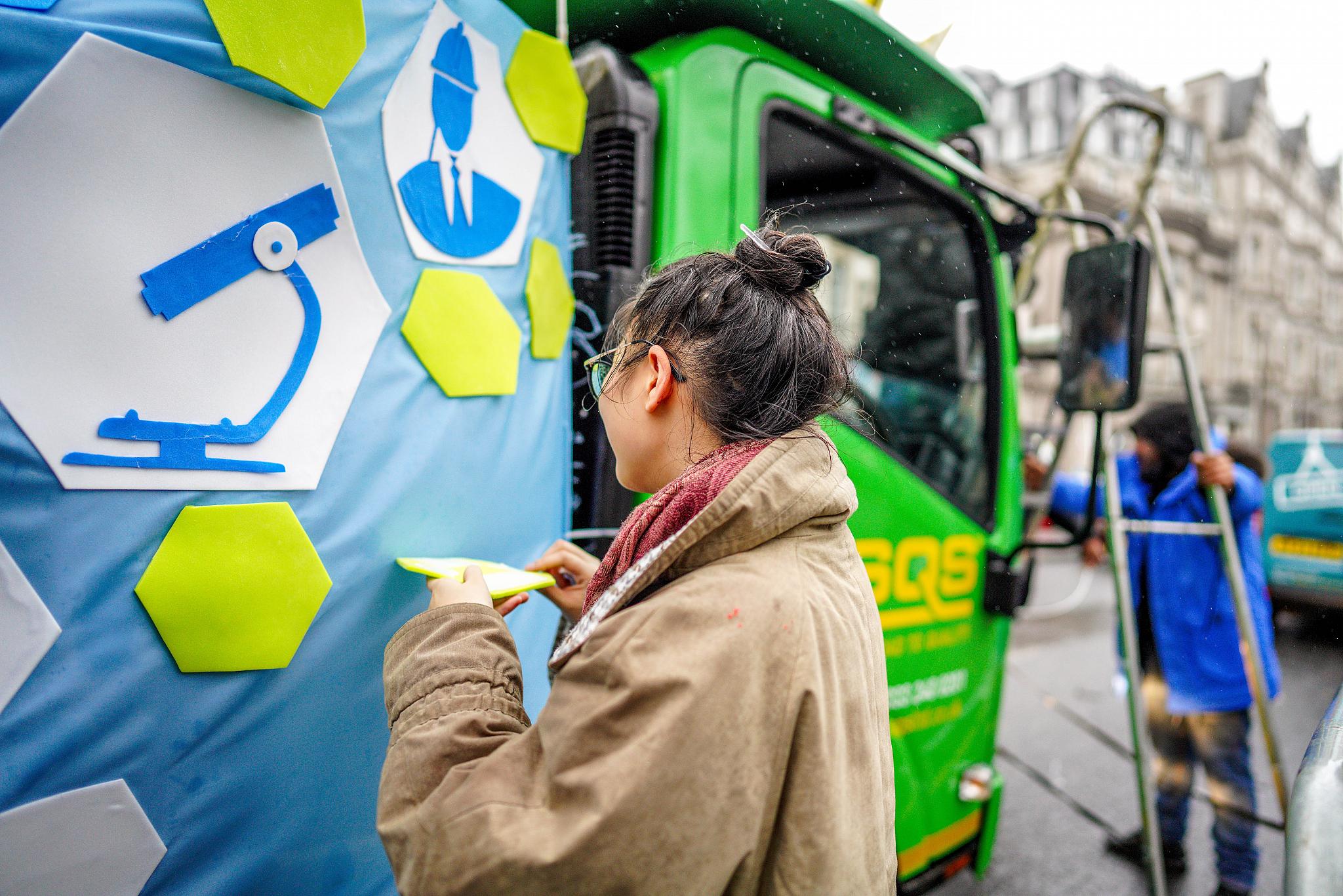 A student working on the design on the side of the truck. 