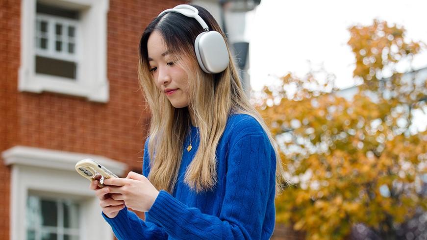 A student listens to headphones on campus