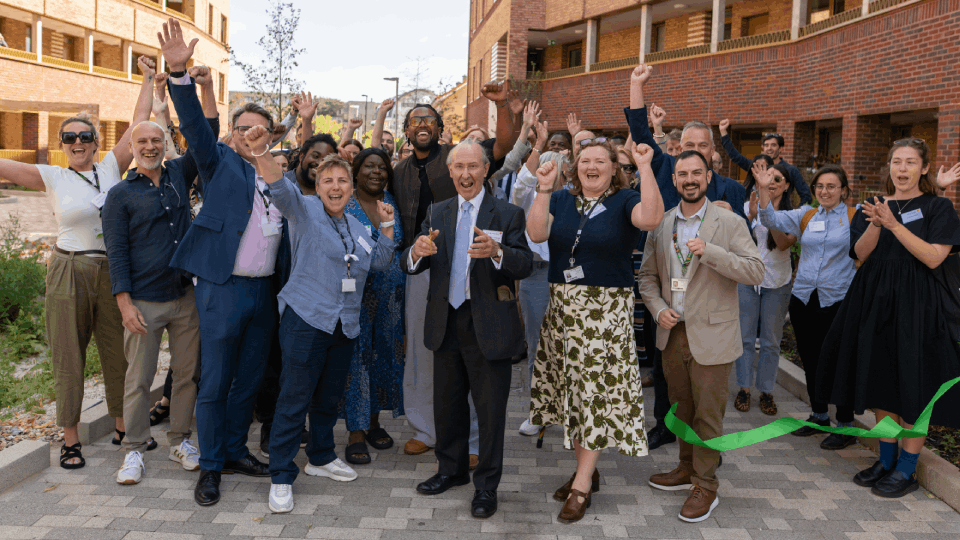 A group of people cheering outside the Melfield Gardens development after Lord Best cut the green ribbon. 