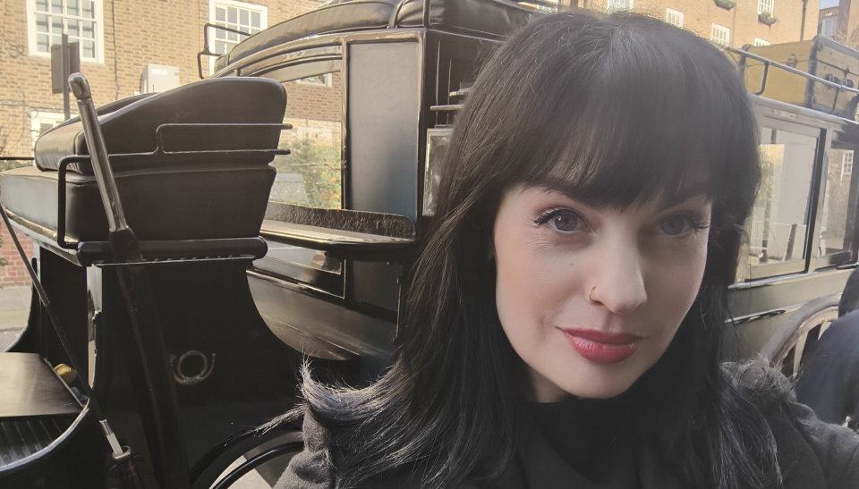 Photograph of Sarah Cox with a carriage in the background