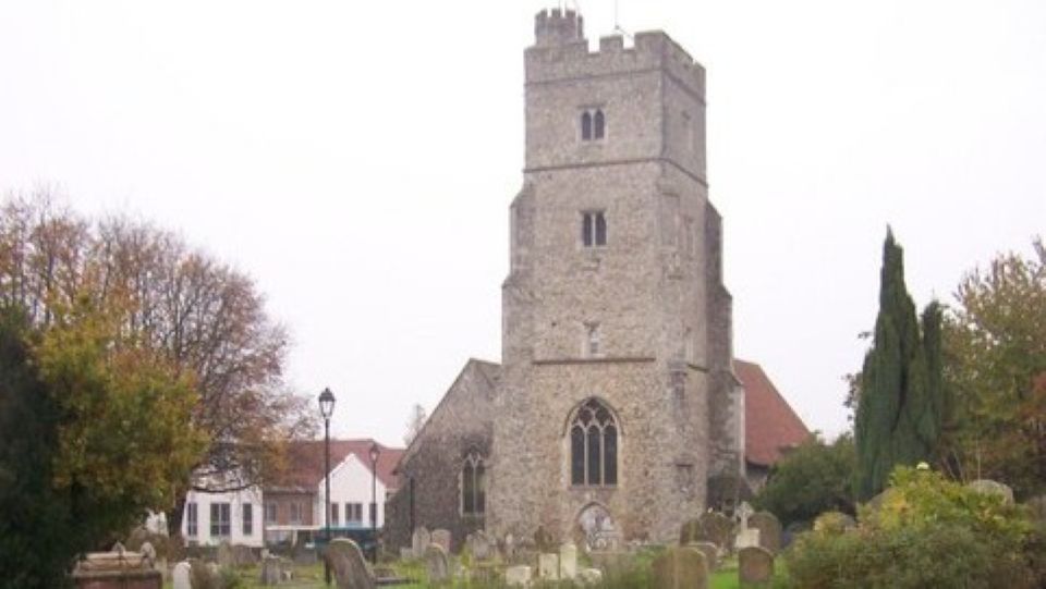 A grey stone church surrounded by a graveyard